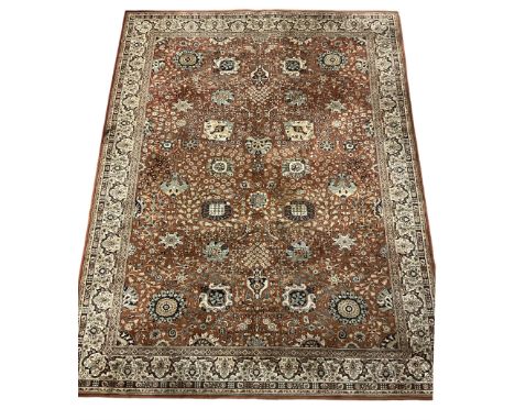 Persian design carpet, rust ground field decorated with large stylised plant motifs surrounded by smaller floral motifs, repe