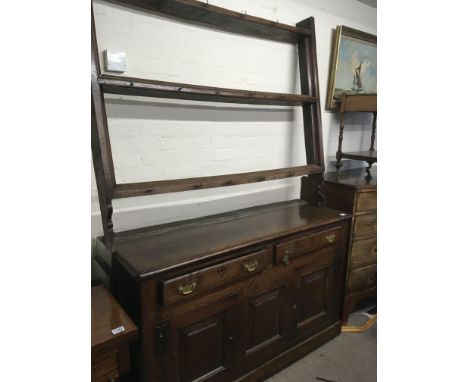 A Vernacular mid  18th century dresser in original condition possible North Wales with a raised open plate rack above two dra