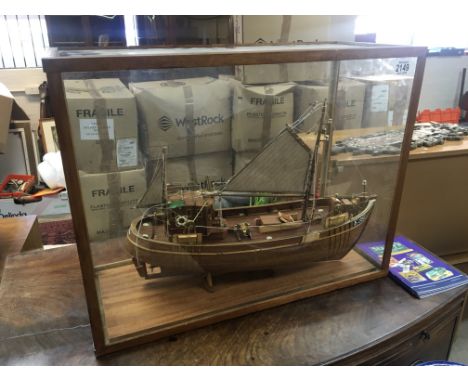 A scratch built detailed wood model of an off shore fishing boat in sail in a glass case. 65x50cm