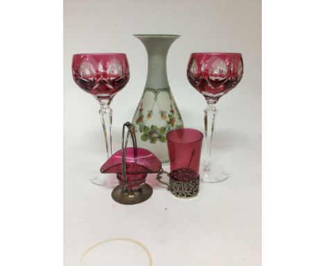 A collection of glass ware including two wine glasses a vase glass beaker with silver rim and a small Cranberry basket .