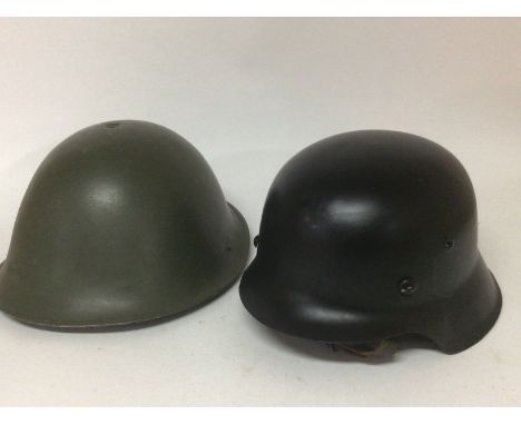 A British Military Hat 1977 M.W.S and a German Third Reich type black painted helmet with a white liner and stamped 3273 (2)-