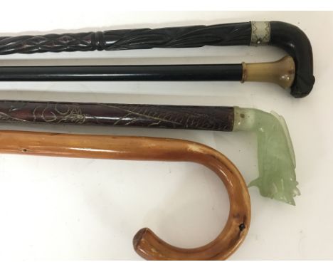 A Chinese walking stick with carved jade top in the form of a stylised dragon and three other walking sticks (4)