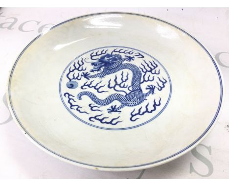 A Chinese blue and white dragon chasing a pearl dish. 27cm wide. Tongzhi Six character mark at base. This lot cannot be poste