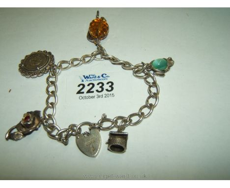 A Silver Charm Bracelet from the 1940's with five charms including a rose, frog, wishing well,globe and three pence