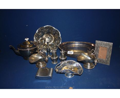 A quantity of silver plate that includes two helmet shaped sugar scuttles with scoops, a cake basket, tea pot, hip flask etc.