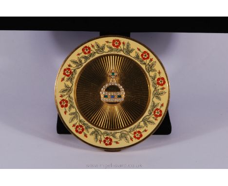 A Vogue Vanities powder Compact, the lid decorated with a floral frieze and a ''jeweled'' orb