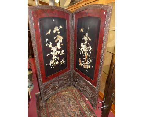 An early 20th century Japanese floral relief carved lacquered, ivory and mother-of-pearl inset two-fold dressing screen, each