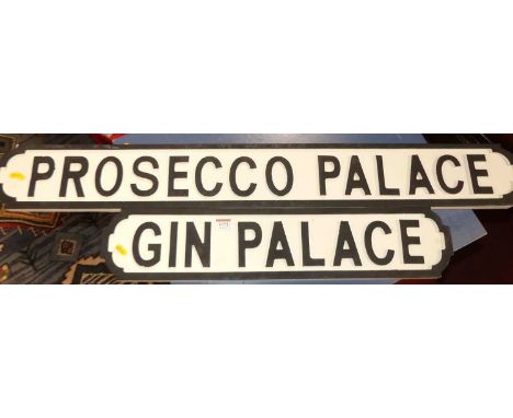 Two painted signs, one titled 'Prosecco Palace', the other 'Gin Palace'