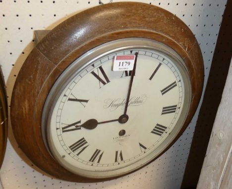 An oak cased circular wall clock, the white enamel dial signed Knight &amp; Gibbins London, single winding hole with drum pen