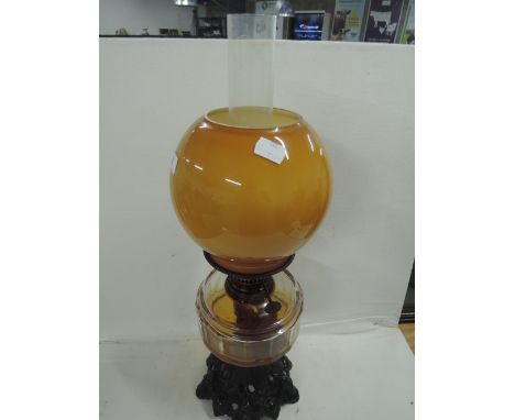 A vintage oil burning lamp with cast base and glass well made by Eltex