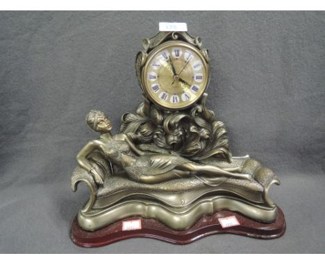 An Art Deco style figural clock with reclining lady on sofa