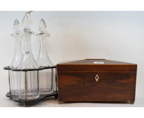 A rosewood tea caddy, of sarcophagus form, 30.5 cm wide, an ebonised three division decanter stand, with three decanters and 
