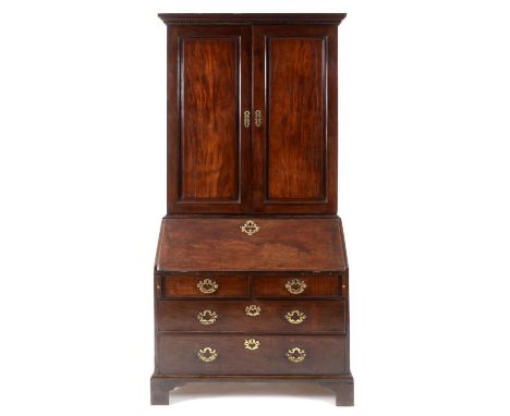 A George III mahogany bureau bookcase, the moulded and dentil cornice above a pair of panel doors, the base with a fall front