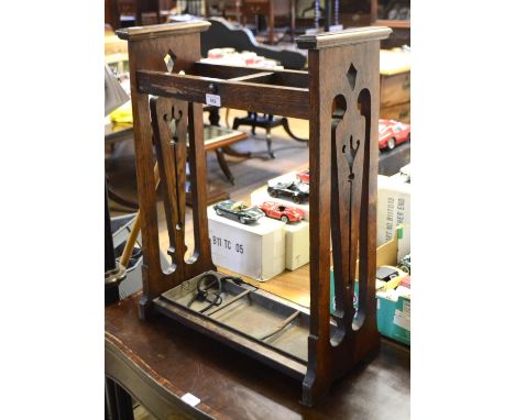 An Art Nouveau style oak two division stick stand, 52 cm wide 