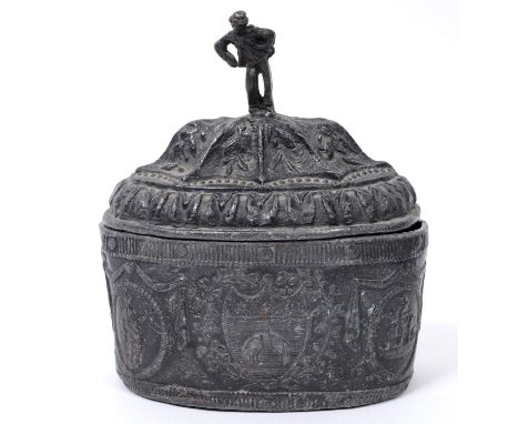 An early 19th century lead oval tobacco box and cover, with figural finial, decorated swags and cartouches, with inner lid, 1