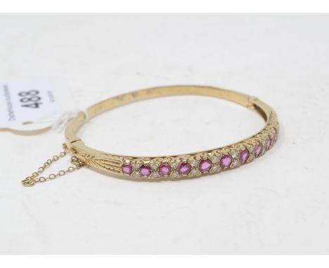 A yellow coloured metal, pink stone and diamond bangle 