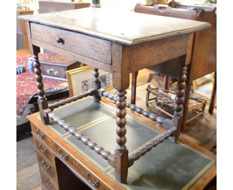 An 18th century oak table, with a frieze drawer, on bobbin turned legs, joined by similar stretchers, 92 cm wide 