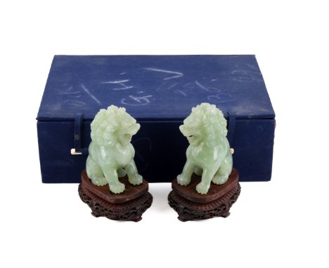 A pair of 20th century Chinese pale green mottled jade Fo dog lions. Seated, with jaws open, H12cm, with pierced carved wood 