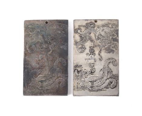 Two 20th century Tibetan white metal zodiac plaques. Decorated with a dragon and phoenix chasing the flaming pearl, and with 