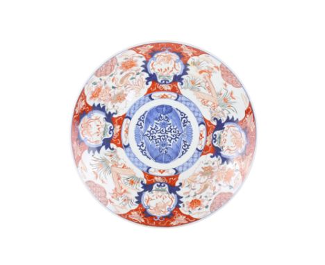 A large 19th century Japanese Imari charger. Decorated with shaped reserves of phoenix and ducks around blue and white lotus,