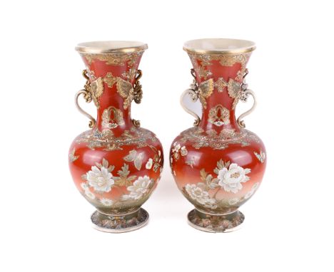 A pair of Japanese Kutani vases. Gilt and decorated with various flowers and butterflies, scroll handles crowned by relief bu