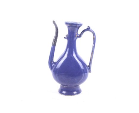 A Chinese 16th century monochrome blue glazed ewer.With slender spout and loop handle meeting the flattened pear form, this r