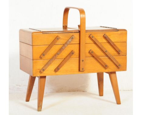 A vintage retro mid 20th century circa. 1960's teak wood metamorphic sewing box having a rounded bar handle with hinged exten