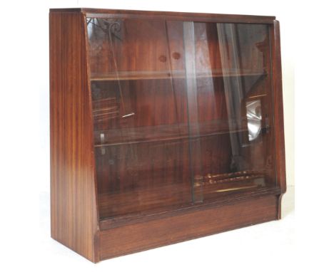 A retro vintage mid 20th century teak glazed sliding doors bookcase in the manner of Herbert E. Gibbs. The cabinet having thr