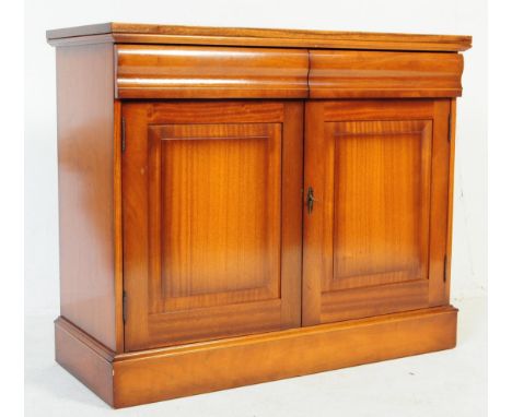 A vintage 20th century regency revival yew wood sideboard buffet cabinet. Of rectangular form with twin parallel drawers atop