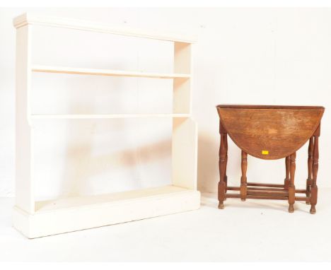 A Victorian 19th century painted mahogany bookcase raised on plinth base with open window shelving and shaped top above. Toge