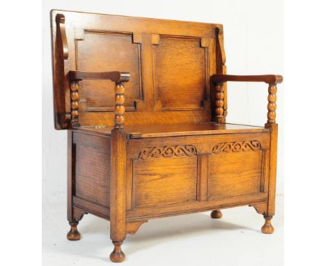 1920's Oak Jacobean revival hall settle - monks bench. Geometric moulded panels with bobbin turned supports having hinged sea