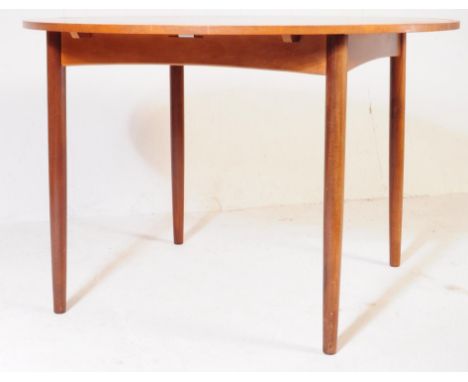 A vintage retro mid 20th century teak wood extending dining table. Of circular round form with tapering circular supports.&nb