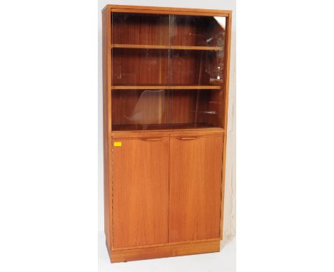 A retro vintage mid 20th century teak wood glass library bookcase cabinet. Of rectangular form with twin glass sliding doors,