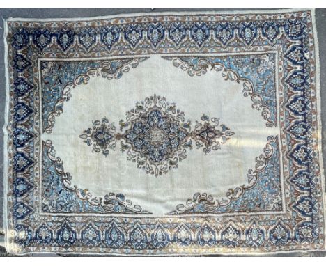 An 20th Century Kirman Persian Islamic floor carpet rug having a central panel in cream and light blue colourway with a delic