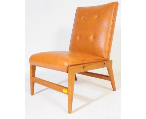 A retro vintage mid 20th century tan vinyl lounge bedroom chair. Rectangular button back with square cushioned seat with angu