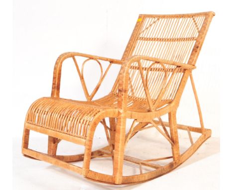A retro vintage mid 20th century circa. 1970's wicker and bamboo rocking chair having shaped armrests with decorative bamboo 