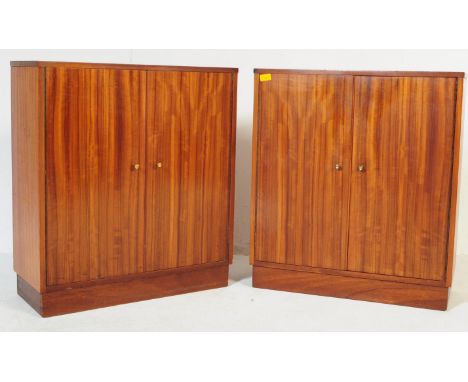 A pair of vintage retro mid 20th century circa. 1960's walnut school cupboards. Each having twin doors with gilt metal conica