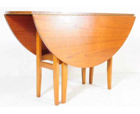 A vintage retro mid 20th century circa. 1960's space saver extending gate leg dining table having circular top over tapering 