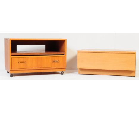 A retro vintage mid 20th century teak wood tv stand cabinet. Rectangular form with open upper shelf with pull our shelf above