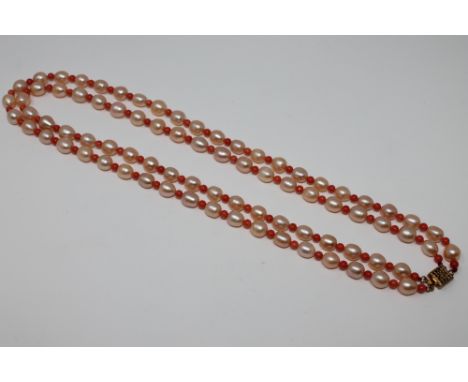 A double strand of fresh water cultured pearl and coral necklace with gilt metal clasp
