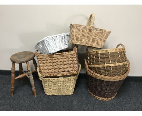 An antique pine stool together with six assorted wicker hand and log baskets 