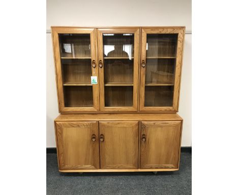 An Ercol light elm glazed triple door bookcase with cupboard base, width 136 cm 