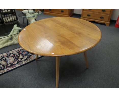 ** LOT DESCRIPTION CHANGE ** An Ercol light elm flap sided circular dining table 