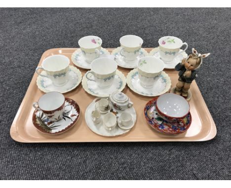 A tray containing six Royal Doulton Picardy china cups and saucers, a Goebel figure, 'Tooth Ache', miniature china Goss tea s