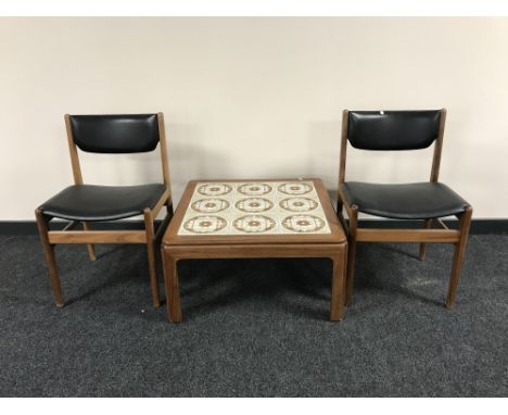 A late twentieth century teak tile top table, together with a pair of teak chairs 