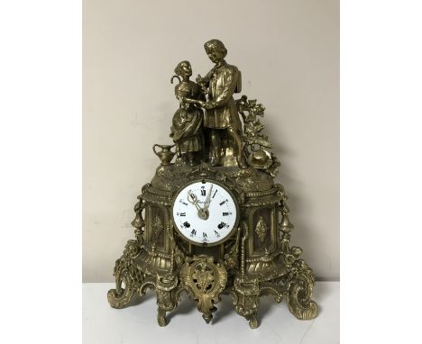 An ornate brass Imperial mantel clock, with figural decoration and enamelled dial
