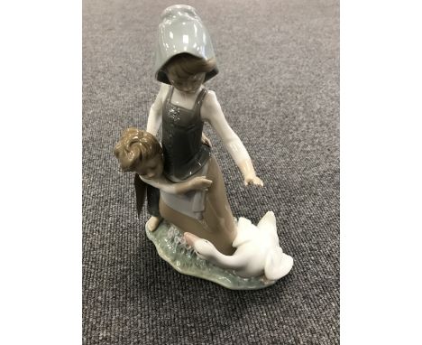A Lladro figure - girl protecting a boy 
