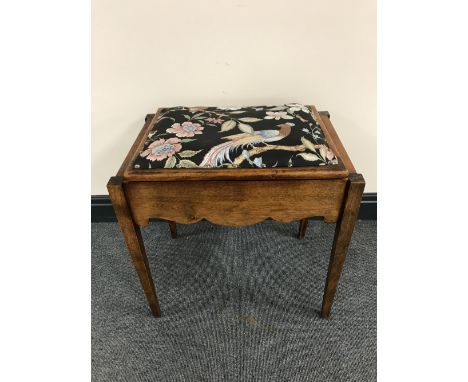 A mahogany storage piano stool containing sheet music 