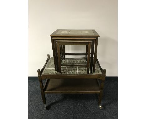 An oak two tier tile top trolley, together with a nest of three oak tile top tables 