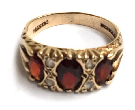 A 9ct gold ring, set with three large red stones and four small white stones 